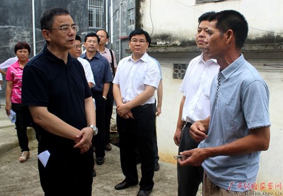 江红兵(左二)听取灵山县平山镇思林村干部汇报有关工作情况