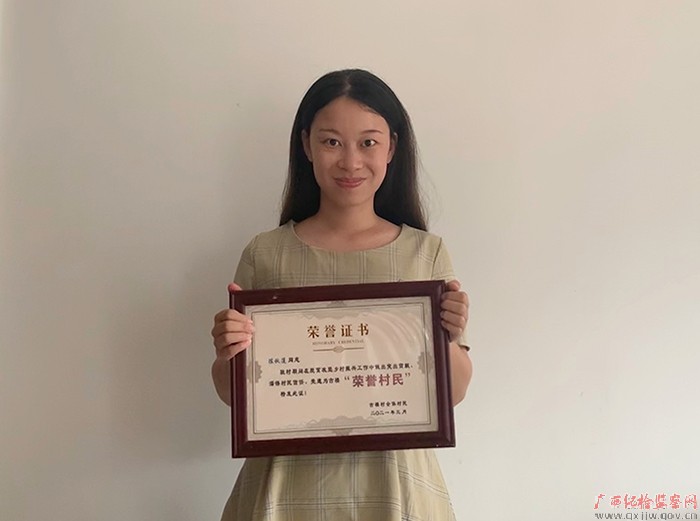 图为陈秋莲收到村民颁发的"荣誉村民"证书